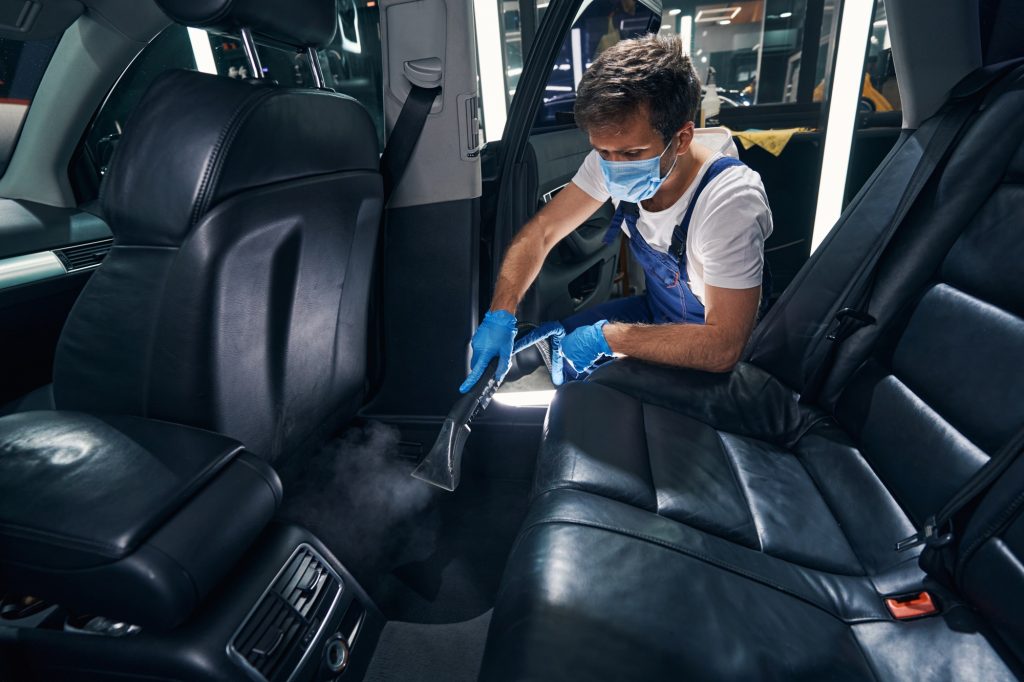 Technician deep cleaning car seats with interior shampoo at CarZone Auto Detailing Burlington